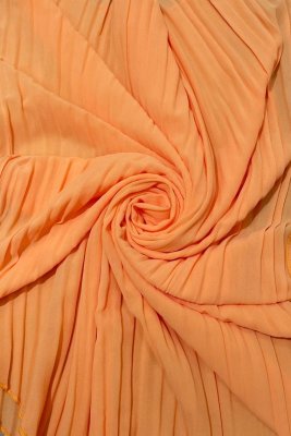 Zoom bild av orange plisserad tunn cape poncho fest