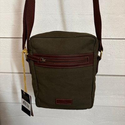 Zoom bild av snygg olivfärgad väska i canvas med läderdetaljer snygg crossover väska unisex barbor stil