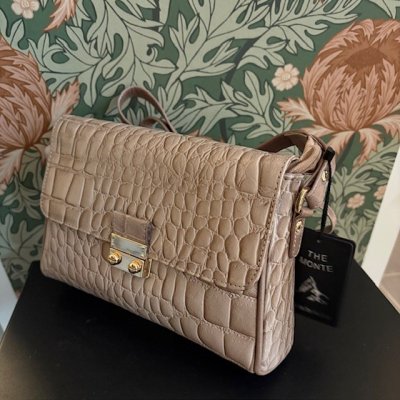 Zoom bild av crocopräglat skinn ljusbeige taupe skinn kroko mönster