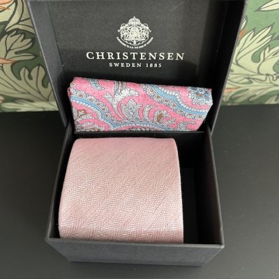 Zoom bild av slips rosa fiskbensmönstrad paisley