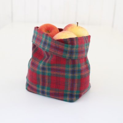 Zoom bild av julkorg i tyg tartan vinröd rutig julbordetvacker klassisk tygkorg tygförvaring till nötterna på julen